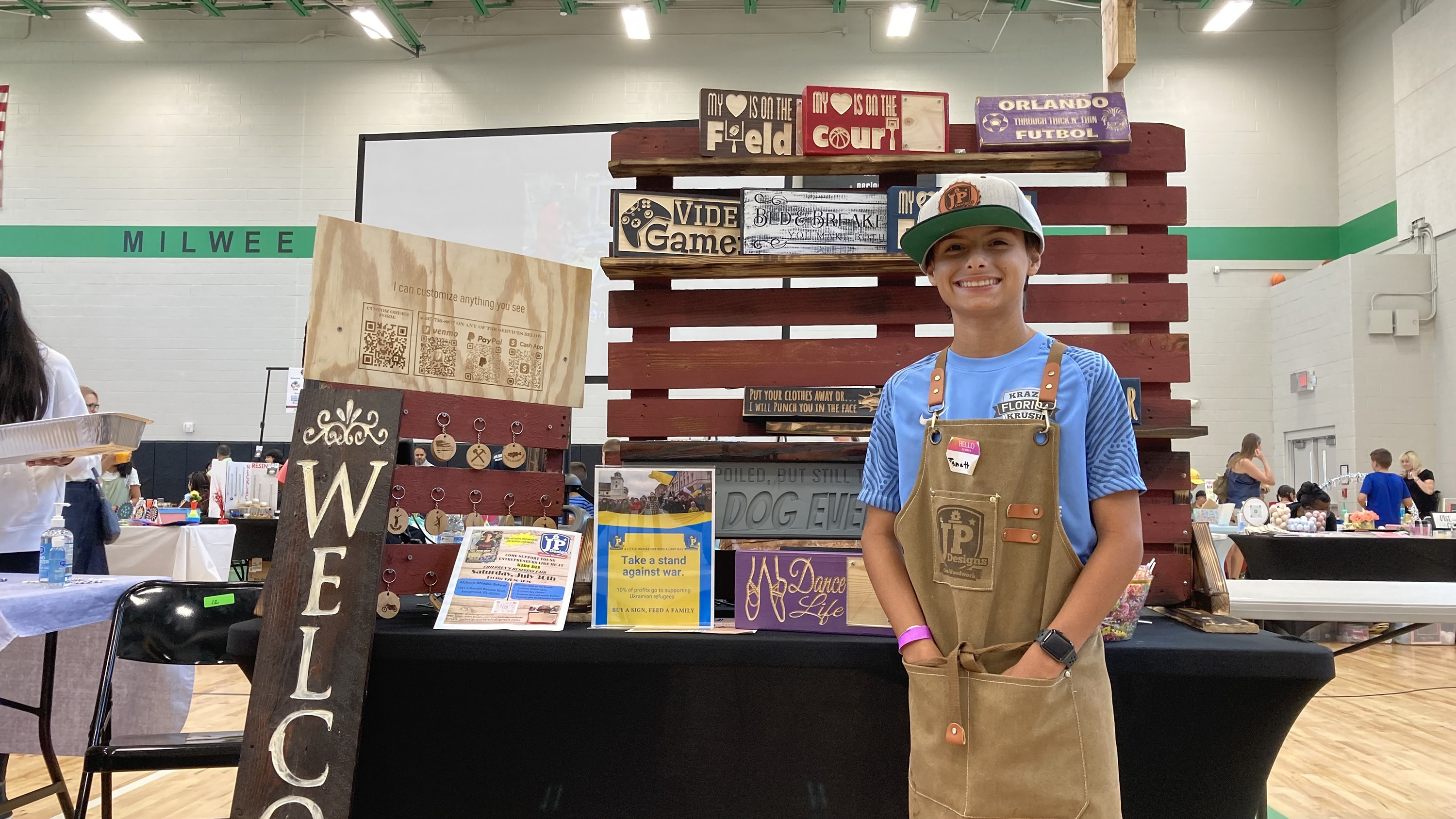 A boy standing in front of wooden signs.