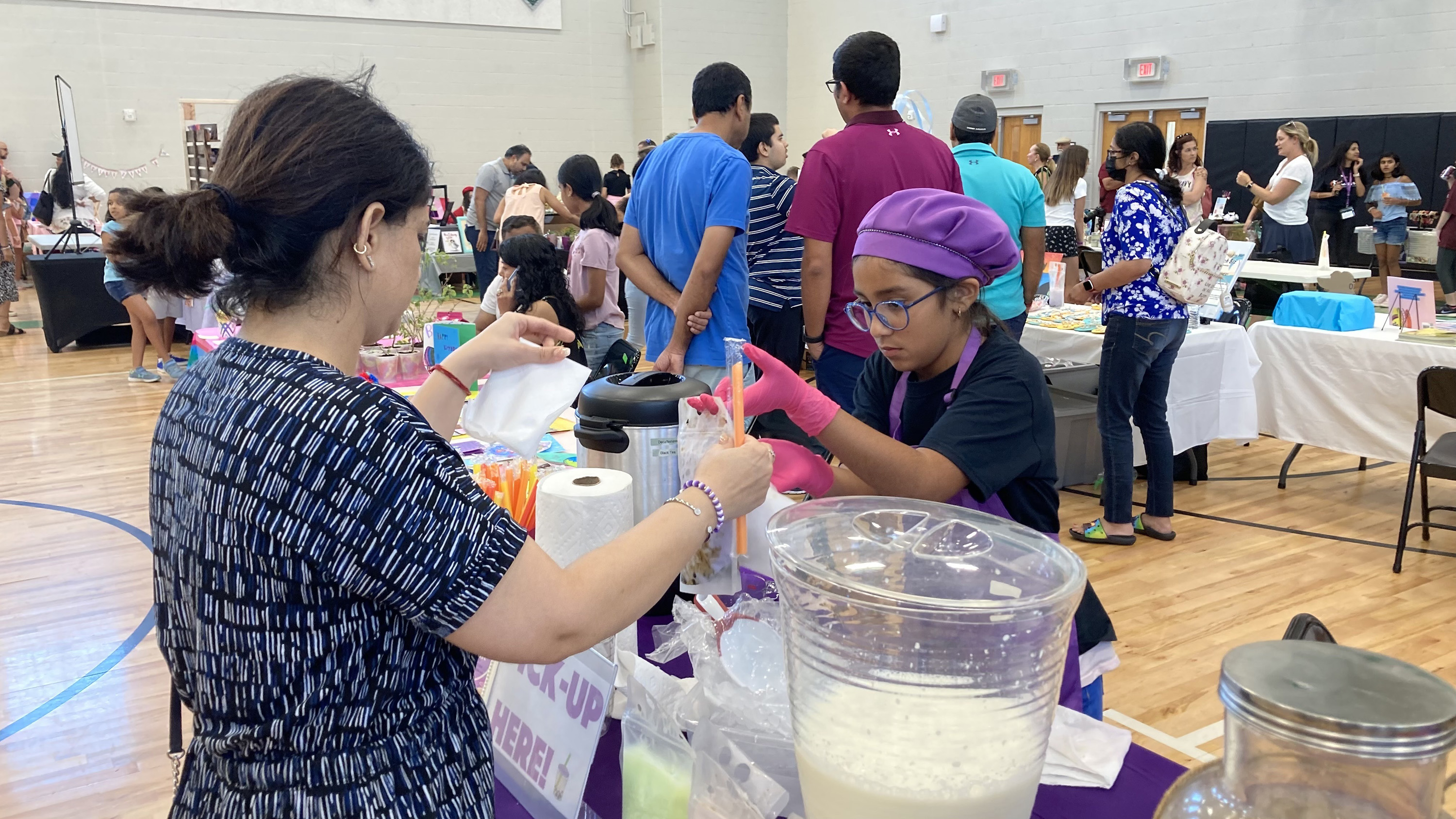 A girls serving customers boba tea.